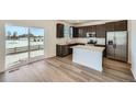 Modern kitchen with dark cabinets, island, and stainless steel appliances at 238 Kino Court, Brighton, CO 80601