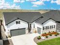 Beautiful exterior elevation of a bright, modern house featuring a two-car garage and manicured front yard at 5707 Cadara Way, Parker, CO 80134