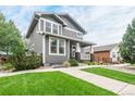 Two-story gray house with white trim, front porch, and landscaped lawn at 16911 Buffalo Valley Path, Monument, CO 80132