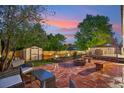 Inviting backyard featuring a brick patio with fire pit, shed, and seating area at 18601 E Louisiana Ave, Aurora, CO 80017
