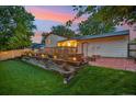 Backyard featuring a stone retaining wall with flowers, patio with fire pit at 18601 E Louisiana Ave, Aurora, CO 80017
