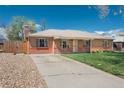 Attractive single-story brick home with a large driveway, well-kept lawn, and a charming exterior at 1077 Salem St, Aurora, CO 80011