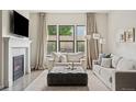 Bright living room with a fireplace, large windows, and comfortable seating arrangement perfect for relaxation at 10929 Endeavor Dr, Parker, CO 80134