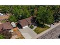 Aerial view of a brick home with an attached garage and lush green trees surrounding the property at 12771 W 6Th Pl, Lakewood, CO 80401