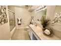 Well-lit bathroom with tiled floor, shower-tub combo, and floral decor at 7695 E Quincy Ave # 207, Denver, CO 80237