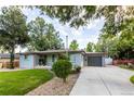 Charming single-story home featuring a paved driveway, attached garage, and a well-maintained front lawn at 7650 W 24Th Ave, Lakewood, CO 80214