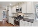Modern kitchen features stainless steel appliances, white cabinets, and sleek countertops at 7650 W 24Th Ave, Lakewood, CO 80214
