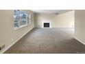 Spacious living room with neutral carpeting and a fireplace at 10547 Pompey Way, Northglenn, CO 80234