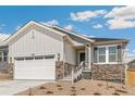 Charming home with a two-car garage, stone accents, landscaped front yard and beautiful white exterior at 4331 Soapberry Pl, Castle Rock, CO 80108