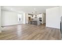 Open-concept living area with wood floors, fireplace, and connected kitchen with modern island at 4331 Soapberry Pl, Castle Rock, CO 80108