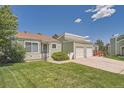 Quaint home with attached two-car garage and a well-manicured lawn and landscaping at 16149 E Rice Pl # A, Aurora, CO 80015