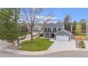 Traditional two-story home with a lush green lawn and mature trees at 9391 W Hialeah Pl, Littleton, CO 80123