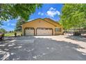 Spacious three-car garage with white doors and ample parking space in a peaceful, rural setting at 25741 E Kettle Cir, Aurora, CO 80016