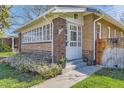 Charming brick home featuring a welcoming front door and a flower-filled garden at 1230 S Emerson St Dr, Denver, CO 80210