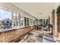 Inviting brick porch with slate flooring, comfortable seating, and bright, airy windows showcasing the outdoor scenery at 1230 S Emerson St Dr, Denver, CO 80210