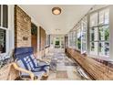 Inviting sunroom with a comfortable chair, tiled floor, and ample light from surrounding windows at 1230 S Emerson St Dr, Denver, CO 80210