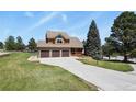 Beautiful home featuring a spacious driveway, well-maintained lawn, and mature trees at 6279 Cheyenne Ct, Parker, CO 80134