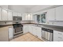 Clean white kitchen with stainless steel appliances, tile floors, and a bright window at 723 Eaton Rd, Palmer Lake, CO 80133