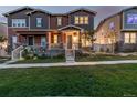 Charming home exterior with inviting front porch, landscaped yard, and warm evening glow at 13860 Ash Cir, Thornton, CO 80602