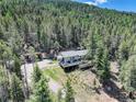 Breathtaking aerial view of a charming home nestled among tall trees, showcasing its serene and private setting at 8340 London Ln, Conifer, CO 80433
