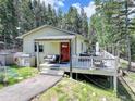 Inviting home featuring a cozy front porch and a spacious deck, ideal for relaxation and entertaining guests at 8340 London Ln, Conifer, CO 80433