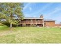 This wooden home features a large lawn area with a spacious deck, perfect for outdoor entertaining at 34101 Columbine E Trl, Elizabeth, CO 80107