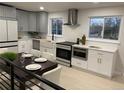 Modern kitchen featuring gray cabinets, stainless steel appliances, and ample counter space with dining area at 6511 S Cedar St, Littleton, CO 80120