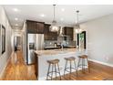 Modern kitchen with stainless steel appliances, granite countertops, dark cabinets, and stylish pendant lighting at 2645 W 24Th Ave, Denver, CO 80211