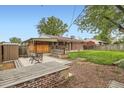 A cozy backyard featuring a patio area with outdoor seating, a well-kept lawn and brickwork accents at 921 Dakin St, Denver, CO 80221