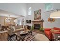 Cozy living room featuring a brick fireplace, comfortable seating, and an adjacent dining area at 7630 S Monaco Way, Centennial, CO 80112