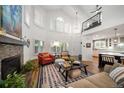 Bright living room with soaring windows, stone fireplace, hardwood floors, and comfortable seating at 7630 S Monaco Way, Centennial, CO 80112