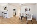 Bright dining area with glass table, modern art, and open layout to the kitchen at 4960 E Donald Ave # 11, Denver, CO 80222