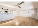 Bright, open-concept living area with hardwood floors, a ceiling fan, and kitchen view at 4960 E Donald Ave # 11, Denver, CO 80222