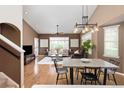 Open-concept living and dining area with hardwood floors, contemporary furniture, and stylish lighting at 22342 E Plymouth Cir, Aurora, CO 80016