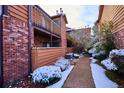View of brick and wood exterior featuring a walkway covered in winter snow at 2277 S Buckley Rd # 102, Aurora, CO 80013