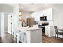 Bright kitchen featuring stainless steel appliances, white cabinets, and a center island with counter seating at 14353 E 1St Dr # 301, Aurora, CO 80011