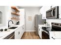 Modern kitchen with white cabinets, stainless steel appliances, and elegant countertops at 14353 E 1St Dr # 301, Aurora, CO 80011