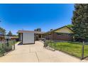 Home exterior showing fenced yard, storage shed, and ample parking space at 10684 Downing St, Northglenn, CO 80233