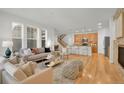 Open-concept living area with hardwood floors, a fireplace, a modern kitchen, and plenty of seating at 5887 S Taft Ln, Littleton, CO 80127