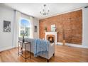 Inviting living room with hardwood floors, exposed brick wall, and cozy fireplace at 3042 N Franklin St, Denver, CO 80205