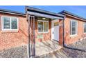 Welcoming front porch with brick facade and stylish black iron support post. Entry door marked 3209 at 3200 Locust St, Denver, CO 80207