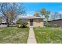 Charming brick home with a tidy front yard and decorative security door at 6933 W 52Nd Pl, Arvada, CO 80002