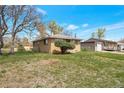 Brick home with a large grassy yard and detached garage at 6933 W 52Nd Pl, Arvada, CO 80002