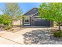 Lovely gray home with stone accents, a two-car garage, a well-maintained driveway and landscaped front yard at 15122 Uinta St, Thornton, CO 80602