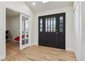Bright foyer featuring hardwood floors, a skylight, and a stylish front door at 6991 S Lee Way, Littleton, CO 80127