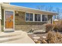 A close-up of the brickwork of the exterior, front door, and house number at 10596 Ura Ln, Northglenn, CO 80234