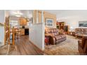 Warm living room with a traditional design, featuring a comfortable leather sofa, wood floors and adjacent kitchen at 10596 Ura Ln, Northglenn, CO 80234