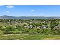 Scenic view of a residential community nestled among green spaces with mountains in the background at 55 S Edge Cliff St, Castle Rock, CO 80104