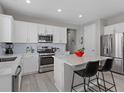 Contemporary kitchen boasts stainless steel appliances, a modern island with seating, and ample countertop space at 55 S Edge Cliff St, Castle Rock, CO 80104