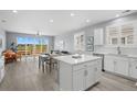 Bright open-concept kitchen features an island, stainless appliances, and a view of the dining and living areas at 55 S Edge Cliff St, Castle Rock, CO 80104